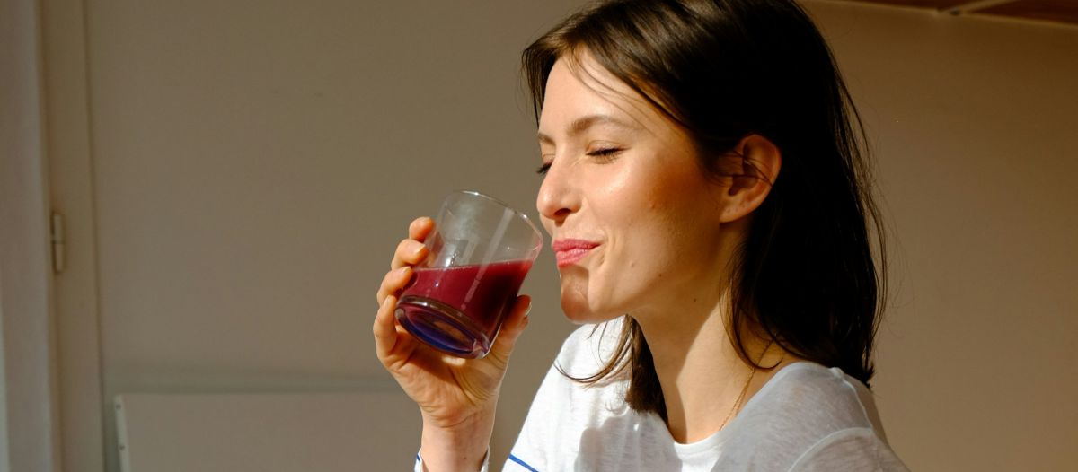 zena pije sok smoothie s vitaminima i antioksidansima